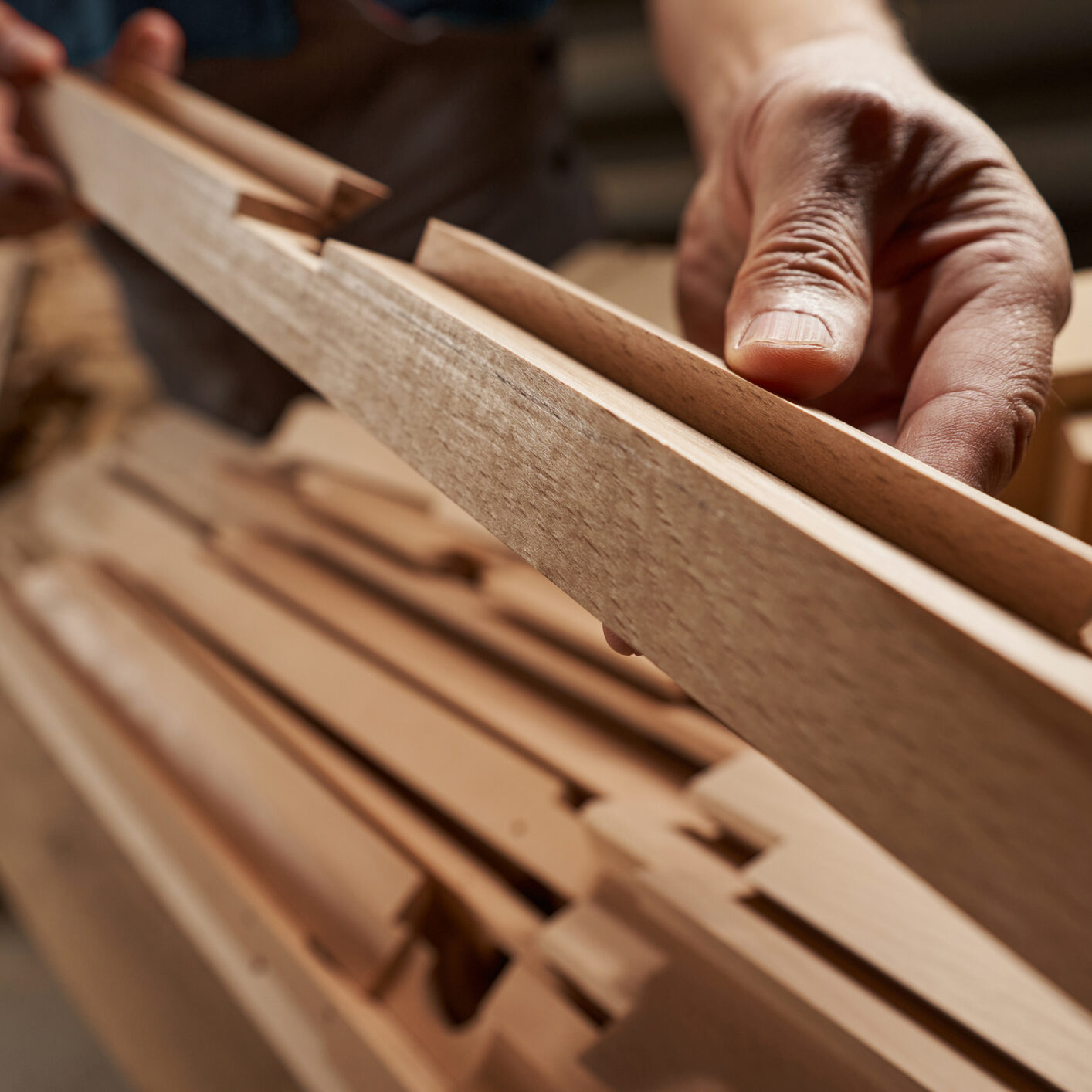 Professional joiner standing at workshop and manufacturing furniture for sale